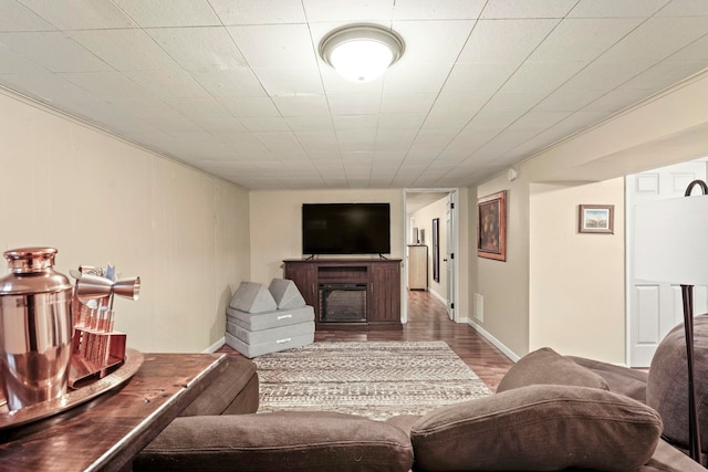 living area with baseboards, a fireplace, wood finished floors, and visible vents