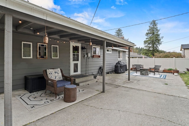 view of patio / terrace featuring fence, a grill, and a fire pit