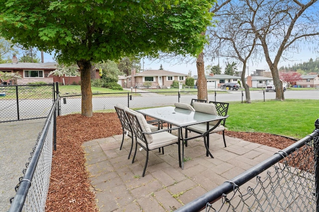 view of patio / terrace with outdoor dining area, fence, and a residential view