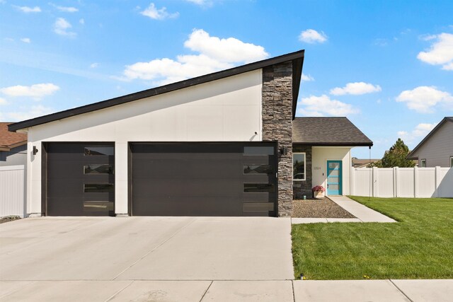 modern home with concrete driveway, stucco siding, stone siding, and a garage