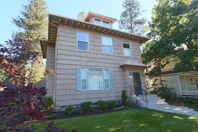 traditional style home with a front yard and a chimney