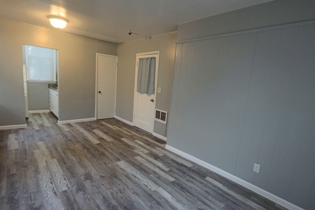 empty room featuring dark wood-type flooring and baseboards