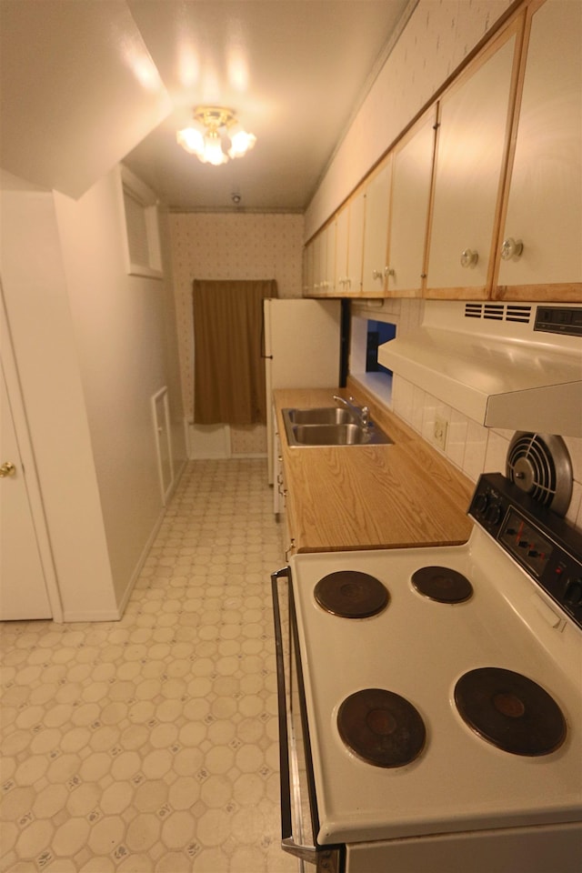 kitchen featuring exhaust hood, electric range, a sink, light countertops, and light floors