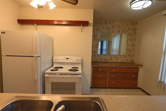 kitchen with white appliances, a ceiling fan, and a sink