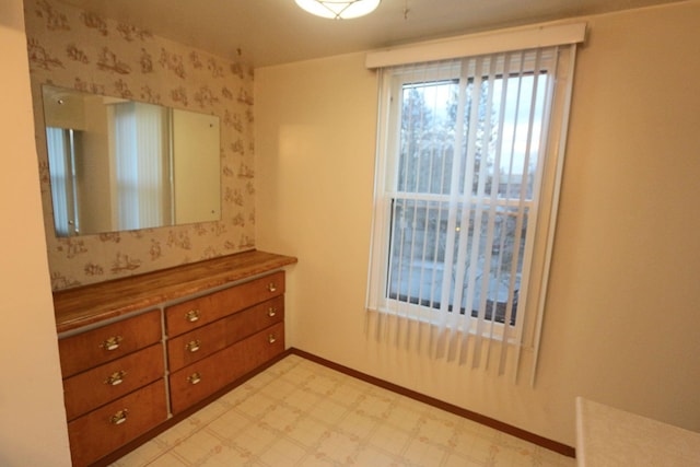 bedroom featuring light floors and baseboards