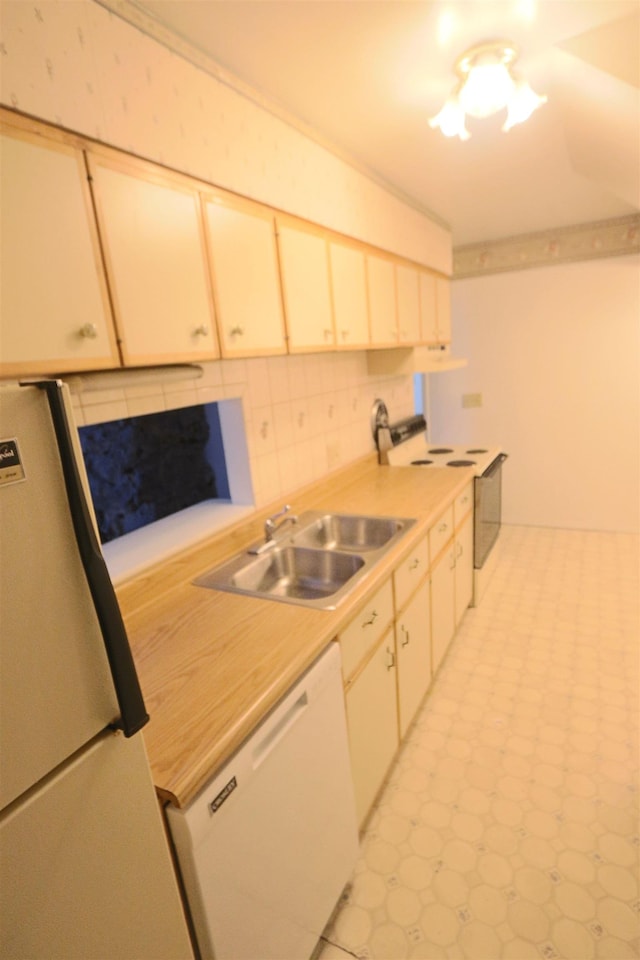 kitchen featuring tasteful backsplash, a sink, white appliances, light countertops, and light floors