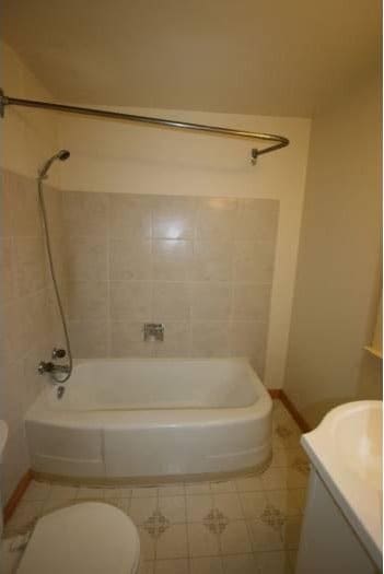 bathroom with vanity, shower / bathing tub combination, tile patterned flooring, and toilet
