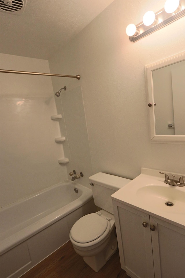 bathroom with vanity, toilet, bathing tub / shower combination, wood finished floors, and visible vents