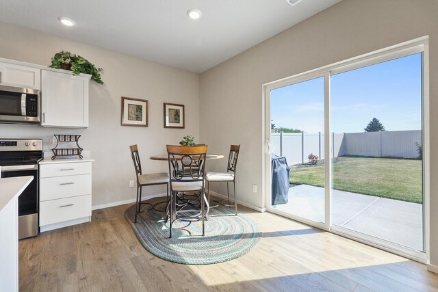 kitchen with light countertops, white cabinetry, appliances with stainless steel finishes, and wood finished floors
