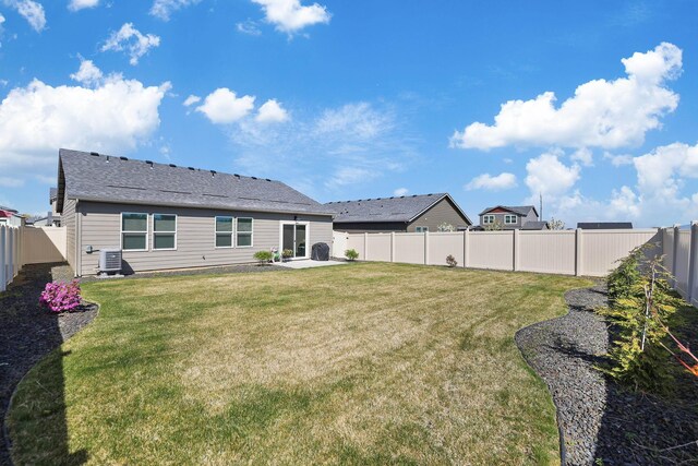 rear view of house with a lawn, a fenced backyard, and a patio