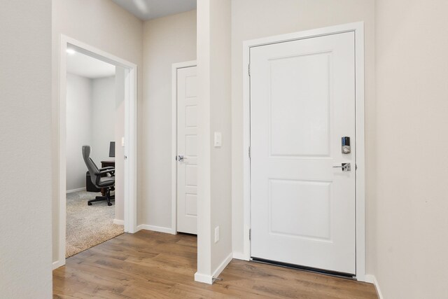 foyer with baseboards and wood finished floors