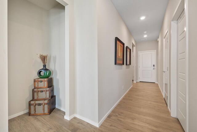 hallway with light wood-style floors, recessed lighting, and baseboards