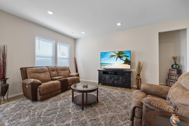 living area with baseboards, recessed lighting, and wood finished floors