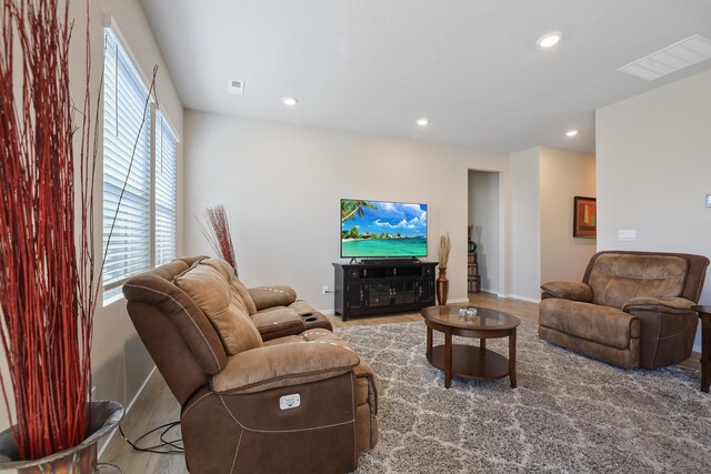 living room with recessed lighting, visible vents, and wood finished floors