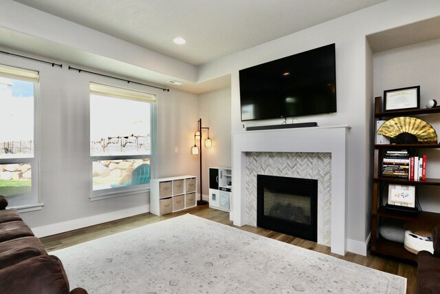 living area with baseboards, a fireplace, recessed lighting, and wood finished floors