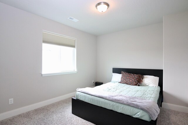 carpeted bedroom with baseboards and visible vents