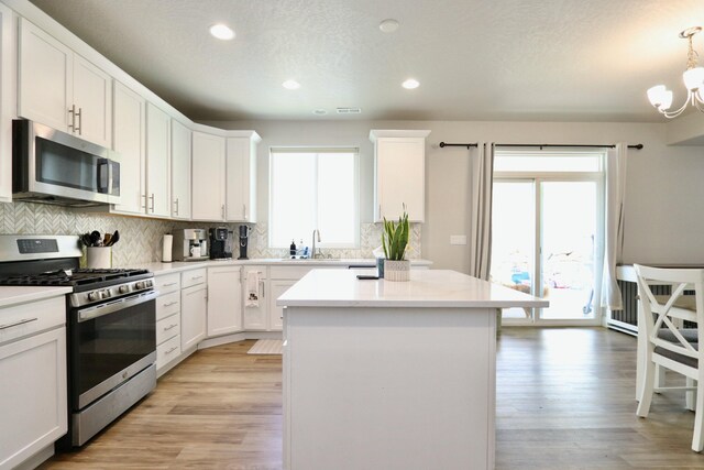 kitchen featuring a center island, a healthy amount of sunlight, tasteful backsplash, and stainless steel appliances