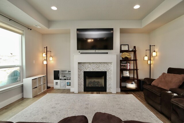 living area with baseboards, recessed lighting, wood finished floors, and a tile fireplace