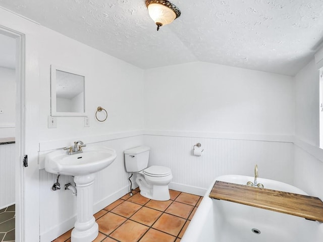 610 Ross St, Davenport, WA 99122 - full bath with toilet, a tub, a textured ceiling, tile patterned floors, and a wainscoted wall