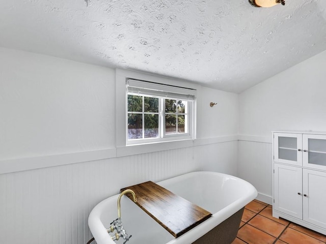 610 Ross St, Davenport, WA 99122 - bathroom featuring a textured ceiling, a freestanding bath, wainscoting, and tile patterned flooring