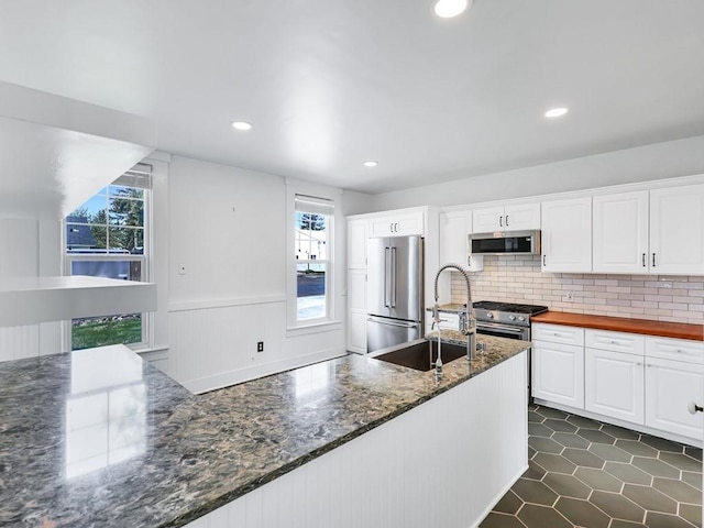 610 Ross St, Davenport, WA 99122 - kitchen featuring high quality appliances, tasteful backsplash, wainscoting, a sink, and white cabinetry