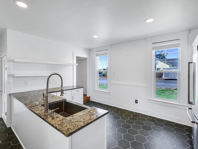 610 Ross St, Davenport, WA 99122 - kitchen with open shelves, wainscoting, a sink, a peninsula, and white cabinetry