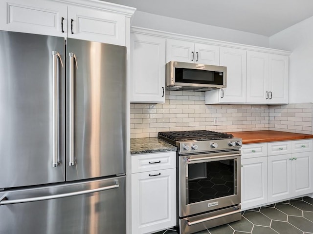 610 Ross St, Davenport, WA 99122 - kitchen with dark tile patterned floors, appliances with stainless steel finishes, tasteful backsplash, white cabinets, and butcher block counters