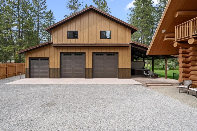 garage featuring a detached garage and fence