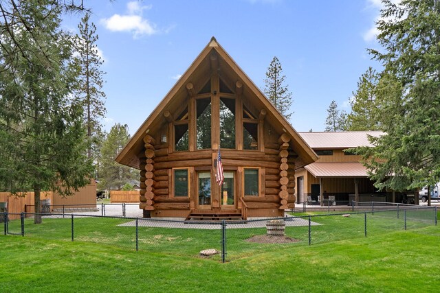 back of house with a lawn, fence, log siding, and metal roof