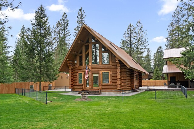 back of property featuring fence, a yard, and log exterior