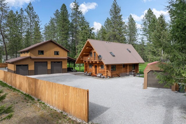 view of front facade featuring a garage, an outbuilding, and log exterior