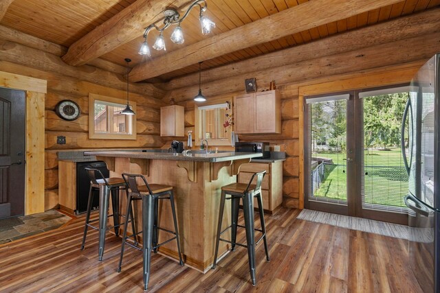 kitchen with open shelves, freestanding refrigerator, a breakfast bar area, dark wood-style floors, and wooden ceiling