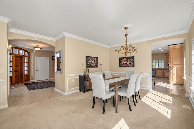 1909 E Pinecrest Rd, Spokane, WA 99203 - dining space featuring arched walkways, crown molding, a chandelier, light carpet, and light tile patterned floors