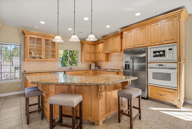 1909 E Pinecrest Rd, Spokane, WA 99203 - kitchen featuring stainless steel appliances, backsplash, a center island, glass insert cabinets, and light stone counters