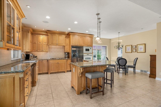 1909 E Pinecrest Rd, Spokane, WA 99203 - kitchen with appliances with stainless steel finishes, a sink, decorative backsplash, a kitchen breakfast bar, and a kitchen island