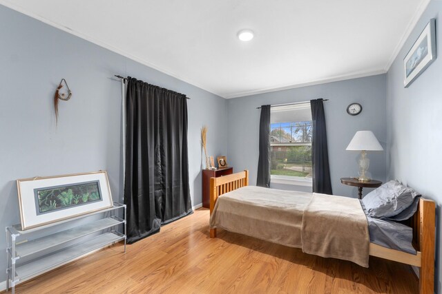 bedroom featuring crown molding and wood finished floors