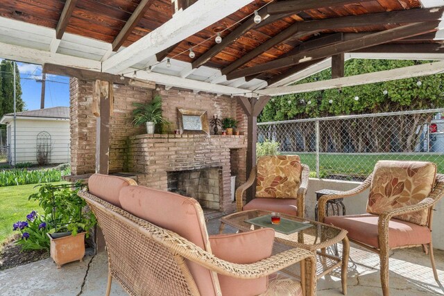 view of patio featuring a gazebo, an outdoor living space with a fireplace, and fence