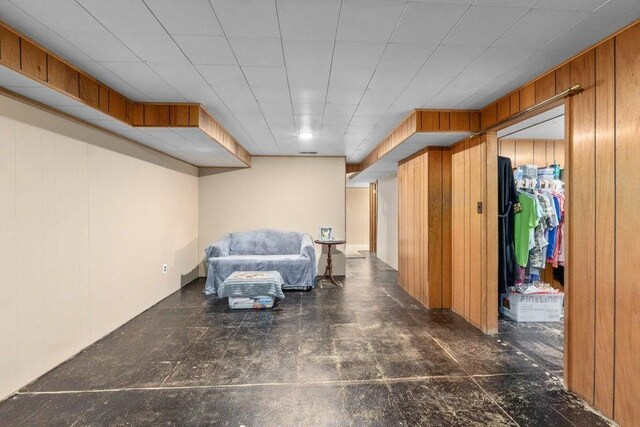 unfurnished room featuring wooden walls
