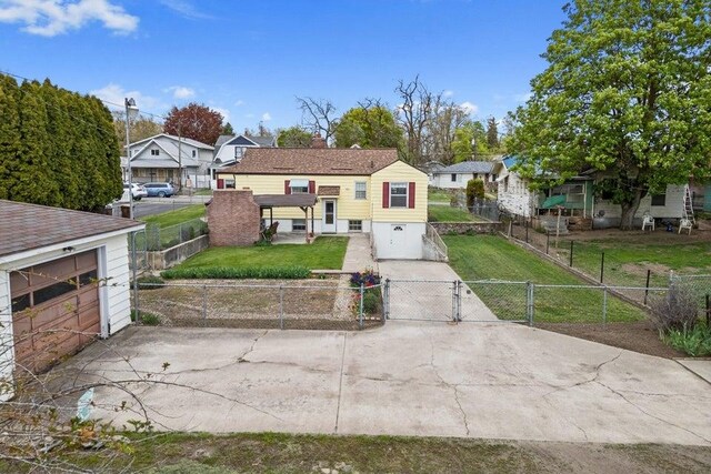 view of front of home featuring a gate, an attached garage, driveway, and a front yard