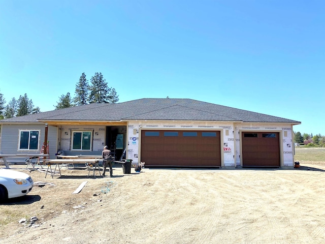 view of front facade featuring dirt driveway and an attached garage