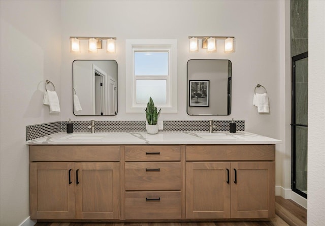 full bath with double vanity, baseboards, and a sink