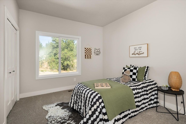 bedroom featuring a closet, baseboards, and carpet flooring