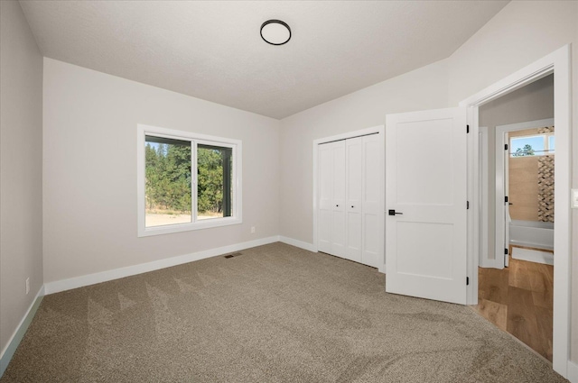unfurnished bedroom with carpet floors and baseboards
