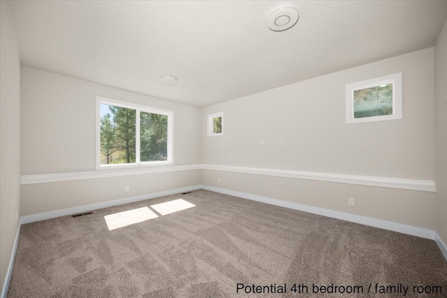 unfurnished room with baseboards, carpet, and visible vents