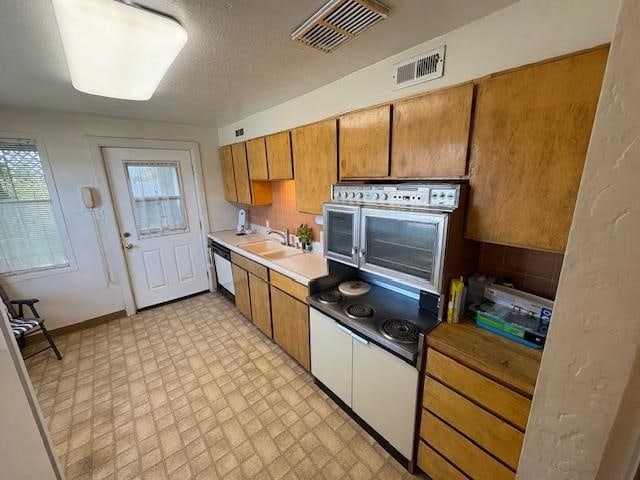 kitchen featuring visible vents, wall oven, dishwasher, and a wealth of natural light