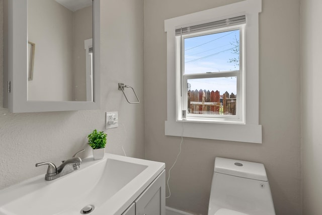 half bath featuring vanity and toilet