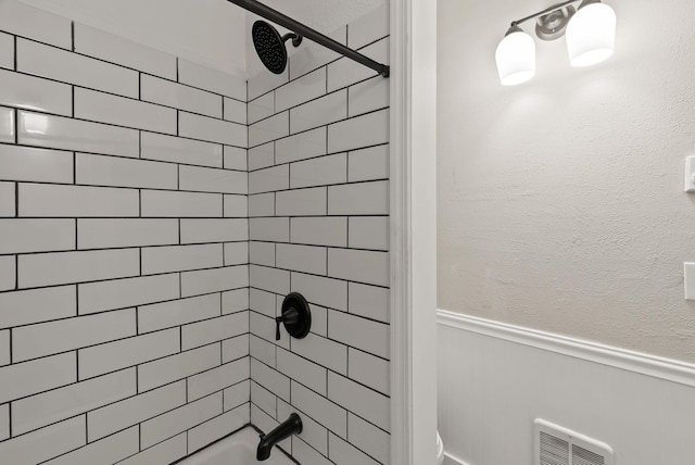 full bathroom featuring wainscoting and shower / tub combination