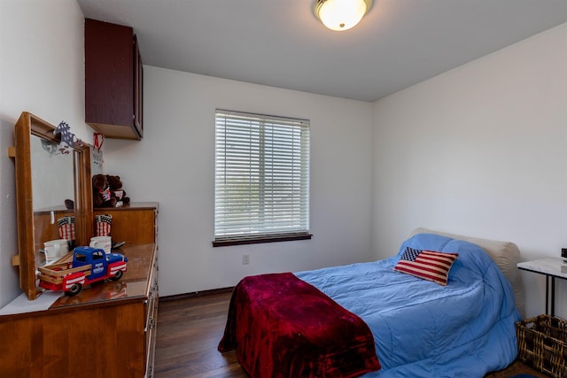 bedroom with baseboards and dark wood-style flooring