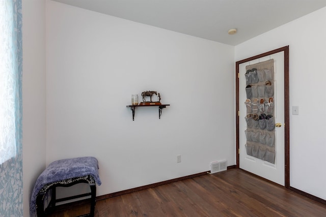 interior space with baseboards, dark wood-style flooring, and visible vents
