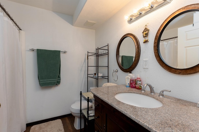 bathroom featuring toilet, wood finished floors, and vanity